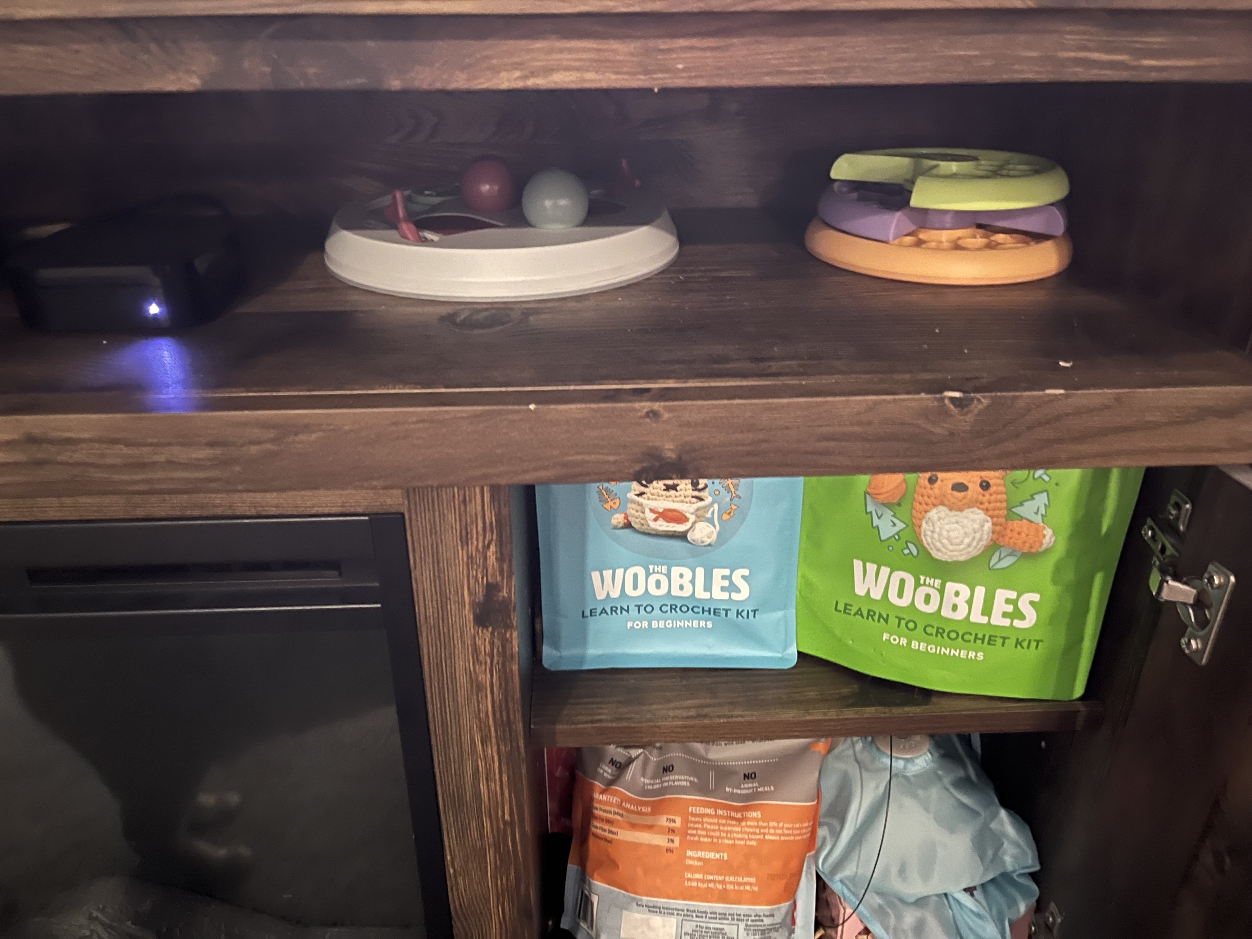 Puzzles on the shelf above the cabinet, treats inside